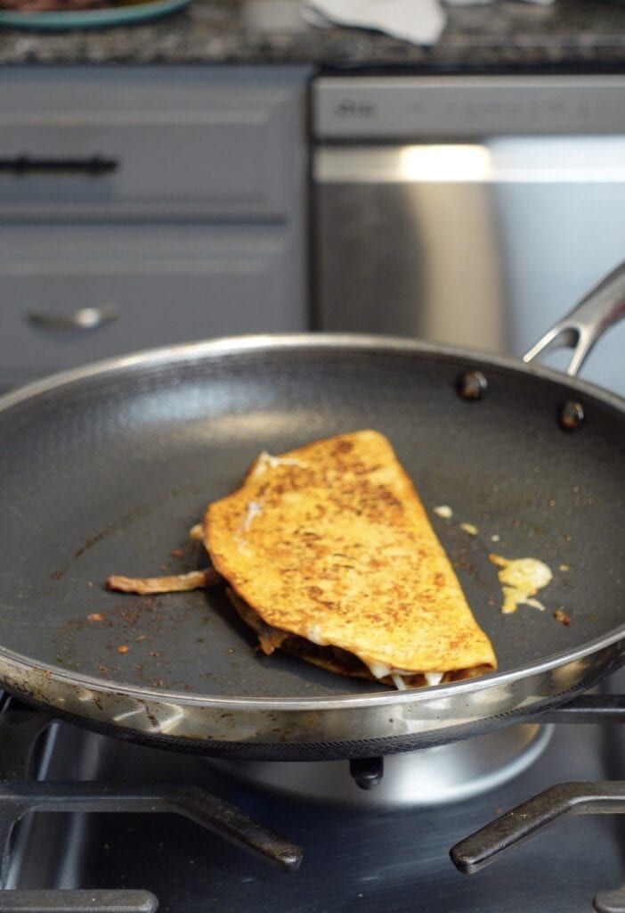 A taco cooking in a skillet.